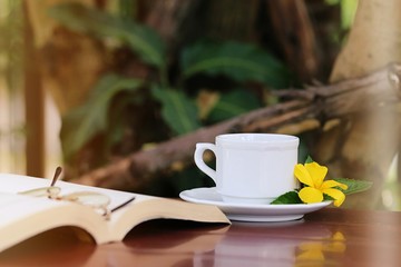 Open books and white coffee cup closeup on table. Books and coffee concept relaxation at home