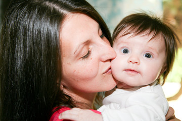 Beautiful mother and her pretty daughter teenager smiling and posing at home