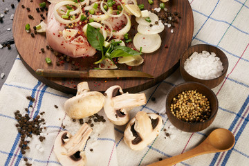 Fresh chicken fillet with fresh vegetables mushrooms onion rosemary and seasoning spices on dark wooden board. Culinary cooking ingredients. Helthy diet food.