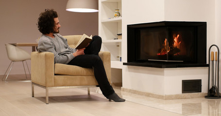young man at home reading book