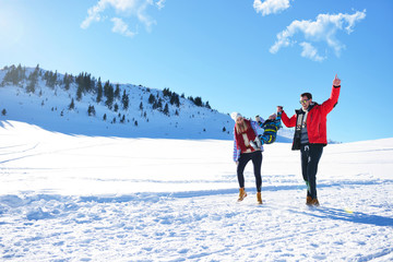 happy young family playing in fresh snow at beautiful sunny winter day outdoor in nature