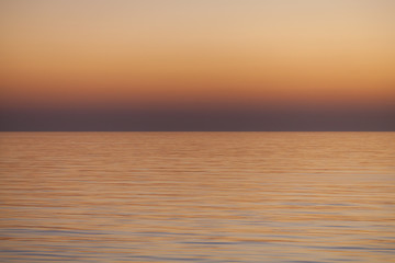 Smooth Sea Sunset Texture / Warm dusk seascape over the smooth ocean and clear sky horizon. 