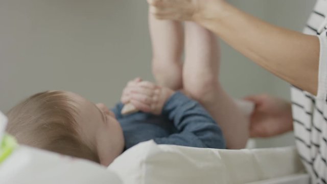Close up of mother cleaning buttocks of baby / Provo, Utah, United States