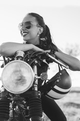 Biker sexy woman sitting on vintage custom motorcycle.