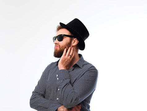 Bearded hipster male in sunglasses and cylinder hat.