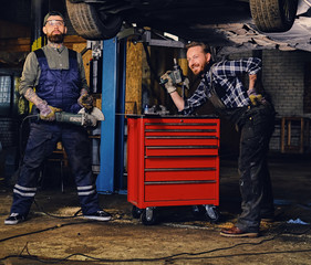 Two bearded mechanics with an angle grinder.