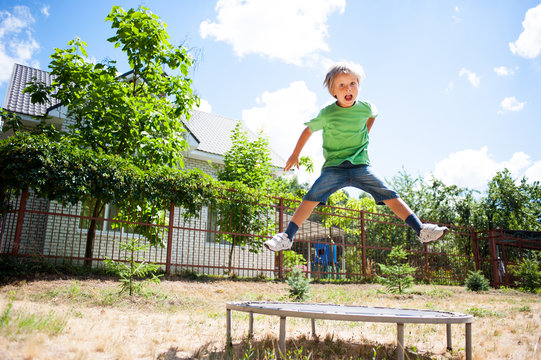 Little Boy Jumping On A Trampoline