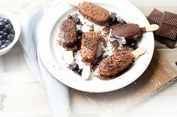 Chocolate ice cream popsicles on white plate