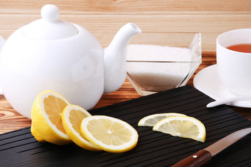 Lemon slices with teapot and bowl of sugar