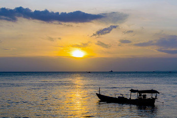 Fototapeta na wymiar Silhouette of fishing boat on the beach in golden sunset