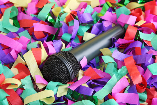 Black microphone on colourful confetti