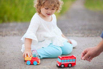 little girl playing with toy cars with her father