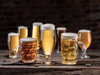 Different glasses of beer on the wooden table.