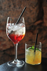 closeup of red and yellow cocktails with lime slice