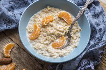 Healthy breakfast - oatmeal with slices of tangerines