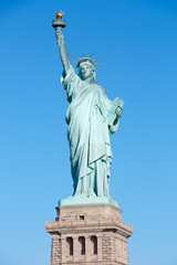 Fototapeta premium Statua Wolności z postumentem w słoneczny dzień, błękitne niebo w Nowym Jorku
