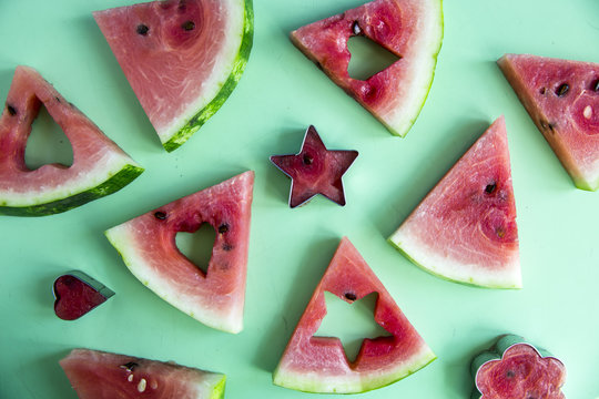 Watermelon slices and carved shape shapes on a green background