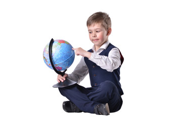 Sitting schoolboy pointing on a globe of world