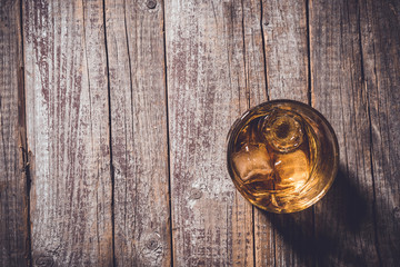 Whiskey glass on an old wooden table. Close up