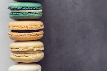 Colorful assorted french macaroons on a gray concrete background.  