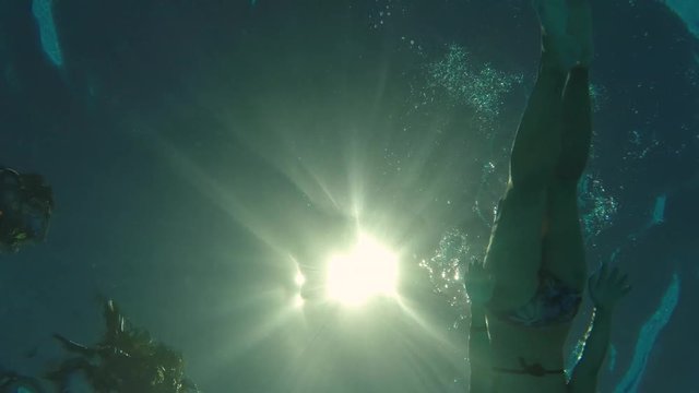 woman swimming backstroke above camera, bottom view