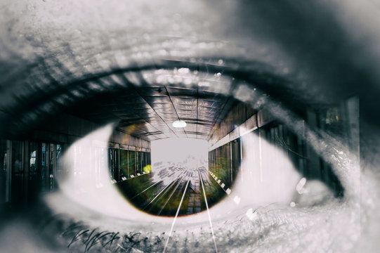 Double exposure of the female eye and tunnel with train car in subway