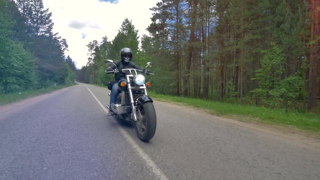 Motorcyclist riding a motorcycle fast on empty road.