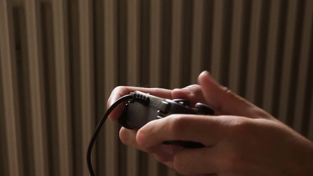 Video game console controller in male hands, man playing entertaining game at home