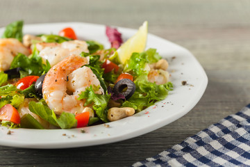 Shrimp salad with tomato, olives and cashew nuts.