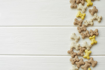 small dog cookies on a white wood background. Dog food. Copy space