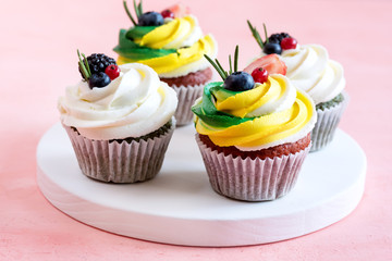 Tasty cupcakes with cream cheese topped with fresh berries Pink background Beautiful cupcakes decorated with colorfull cream cheese Close up