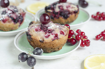 Cupcakes with cherries and powder on a saucer Decorated with fresh berries of currants and porridge. Collection