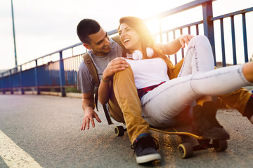 Young attractive couple riding skateboards and having fun © NDABCREATIVITY