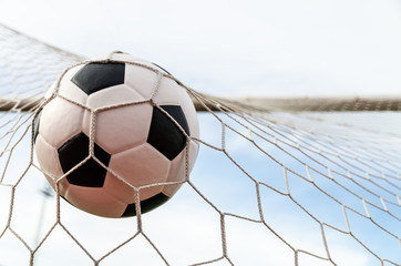 Soccer football in Goal net with the sky field.