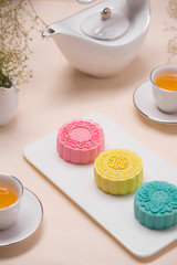 Sweet color of snow skin mooncake. Traditional mid autumn festival foods with tea on table setting.