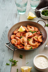 Fried prawns served with garlic sauce and parsley. Wooden 