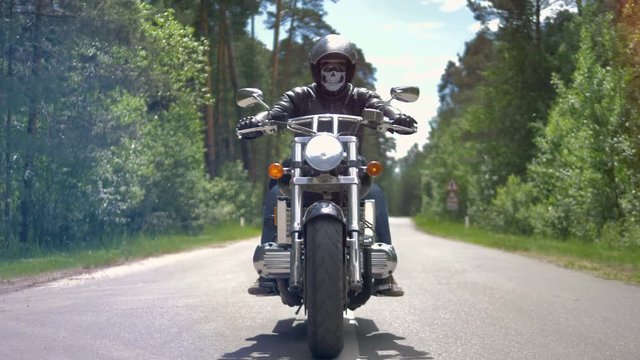 Motorcycle ride on empty road in forest.