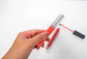 isolated close up woman hold red lip gloss for make up