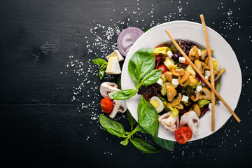Grilled Vegetable Salad, Mushrooms, Feta Cheese and Olive Oil. On a black wooden surface. Free space for your text. Top view.