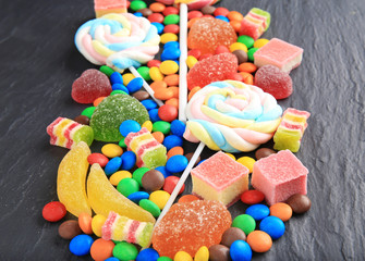 Fototapeta na wymiar Composition of delicious candies on grey table