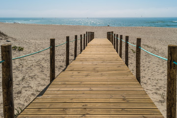 Wooden walkway over the sand dunes to the beach. Beach pathway in Praia de Paramos, Espinho, Portugal.