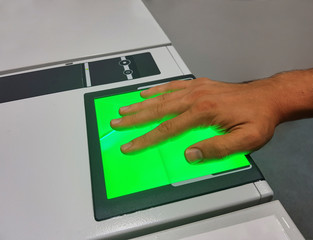 A man uses a fingerprint scanner for identification. Biometrics or cybersecurity concepts. Mobile shot with copyspace.