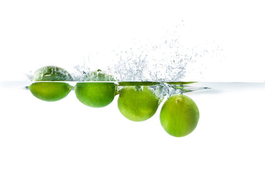 Fresh lime dropped into the water with water splash on a white background