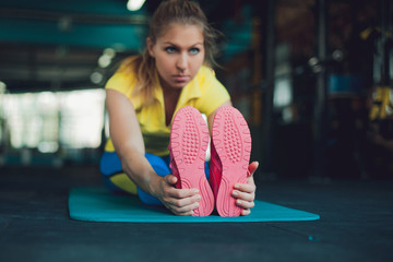 Girl in fitness club. Young woman in sportswear doing stretching, ready to workout