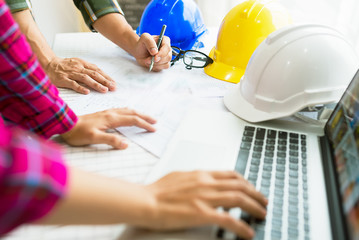 Engineer working on construction project,helmet and laptop on the table.