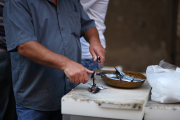 The seller cleans fish at the request of the customer in the fish market