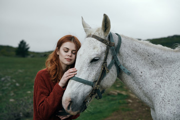 Fototapeta premium Young beautiful woman walking in the mountains with a horse
