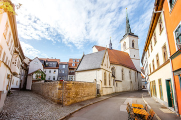 Beautiful street view with colorful buildings and church tower in the old town of Erfurt city...