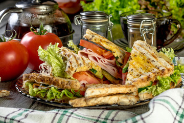 Panini sandwich with ham, tomato and lettuce.