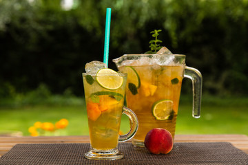 Homemade peach ice tea with lime and lemon balm